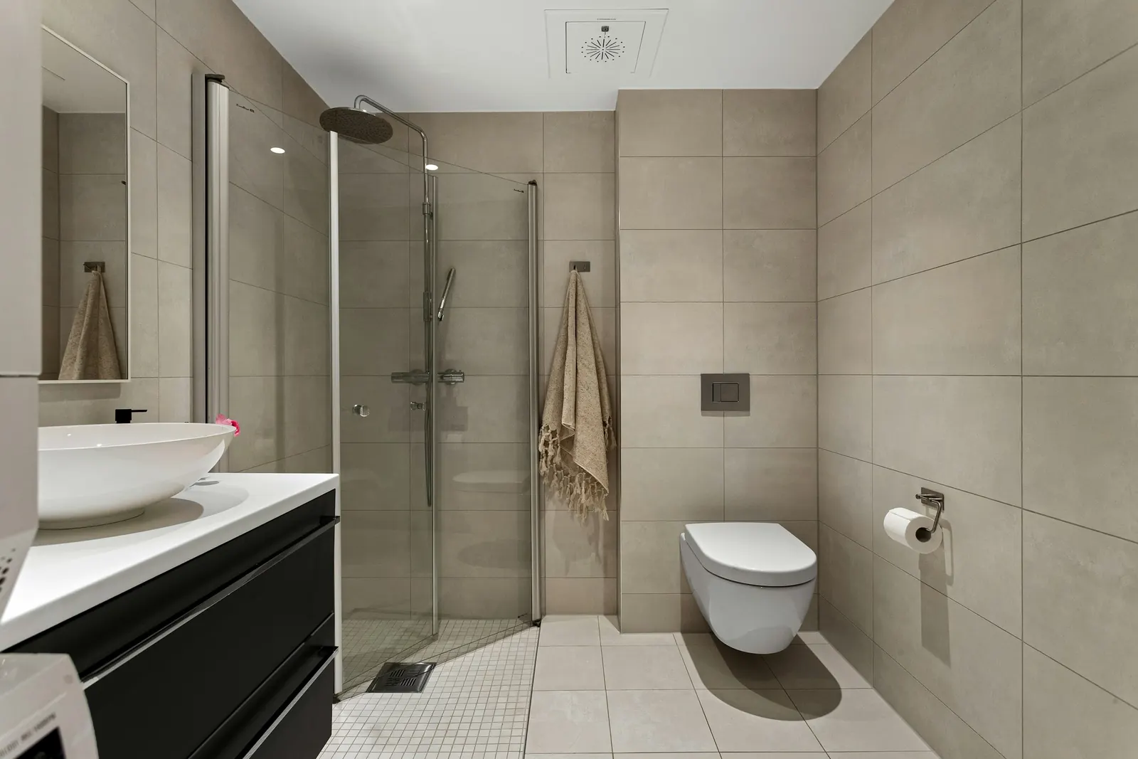 Modernes Bad mit bodengleicher Dusche, Glaswand, großen Fliesen und Hänge-WC