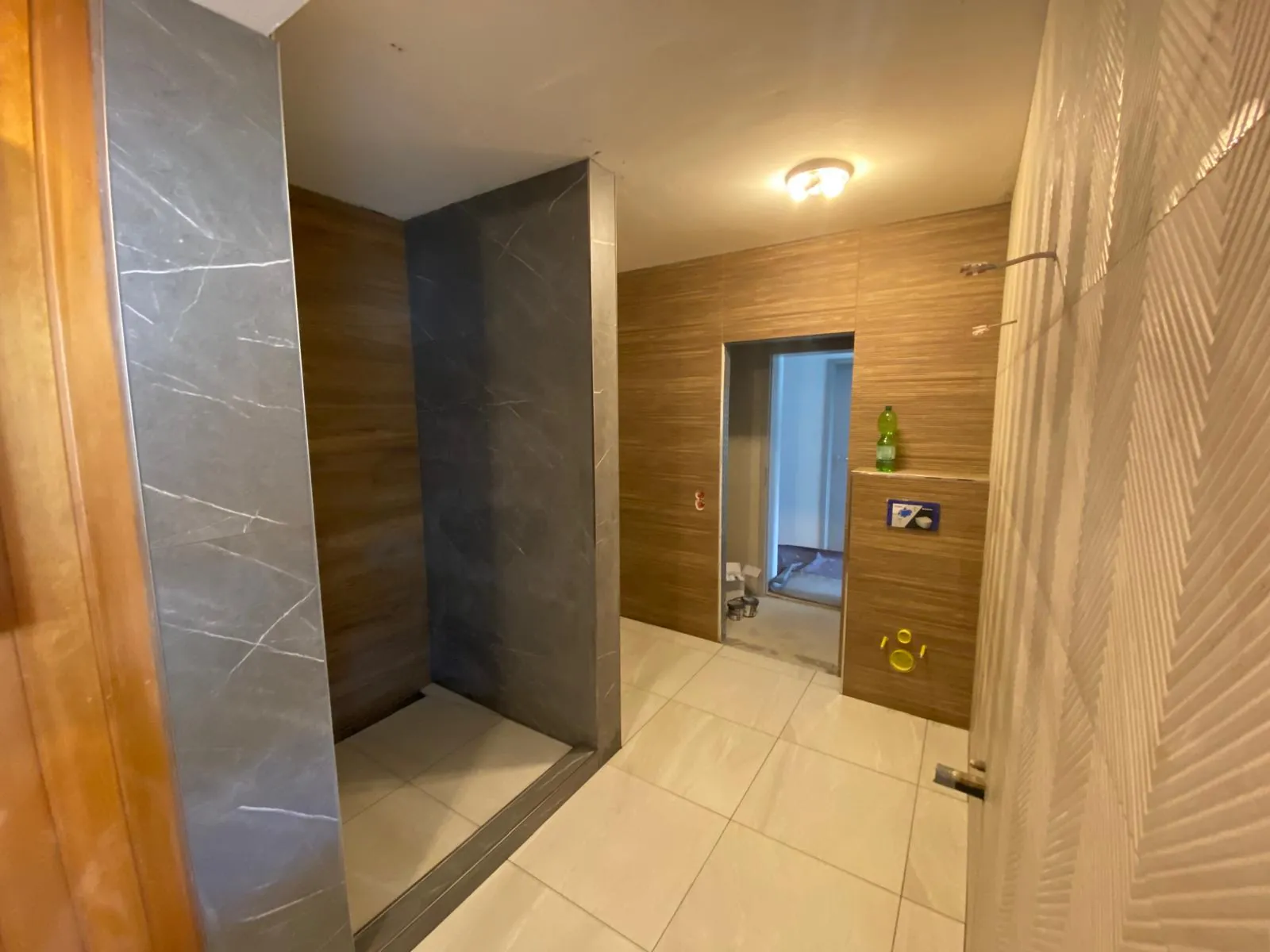 Bad mit begehbarer Dusche, Wandfliesen in Holzoptik und großformatigen Bodenfliesen