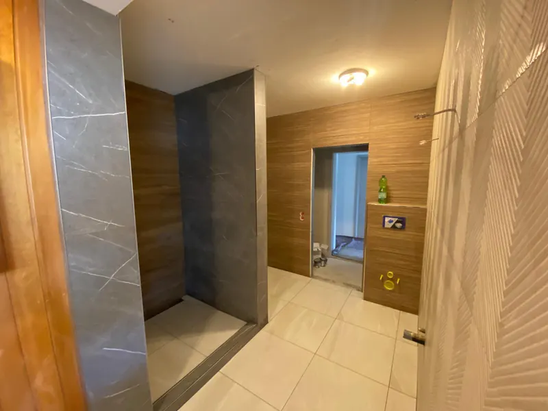 Bad mit begehbarer Dusche, Wandfliesen in Holzoptik und großformatigen Bodenfliesen