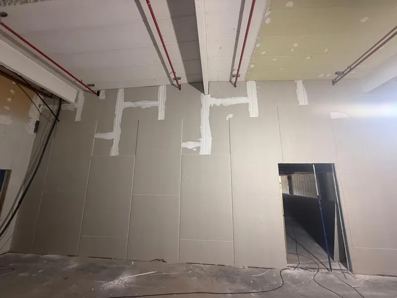 Neue Trockenbauwand mit verspachtelten Fugen in einer Gewerbefläche