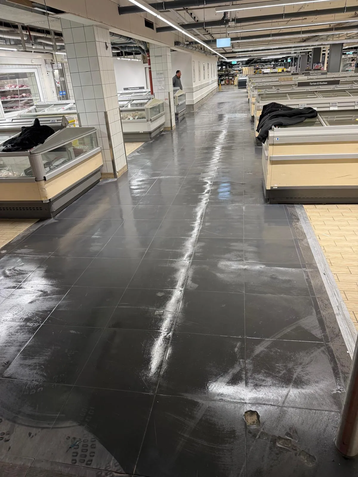 Verkaufsfläche eines Supermarkts nach dem Umbau mit neuem Fliesenboden und Kühltheken