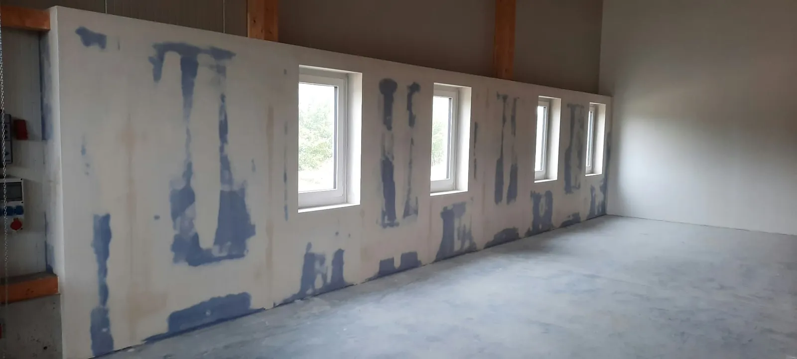 Fertig gespachtelte Trockenbauwand vor einer Fensterfront