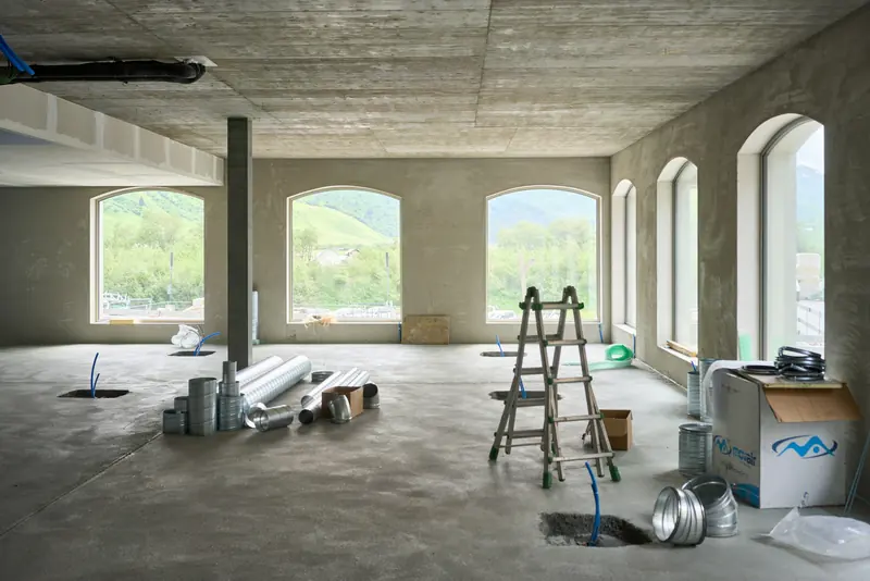 Entkernte Fläche mit Rundbogenfenstern, Leiter und Baumaterial