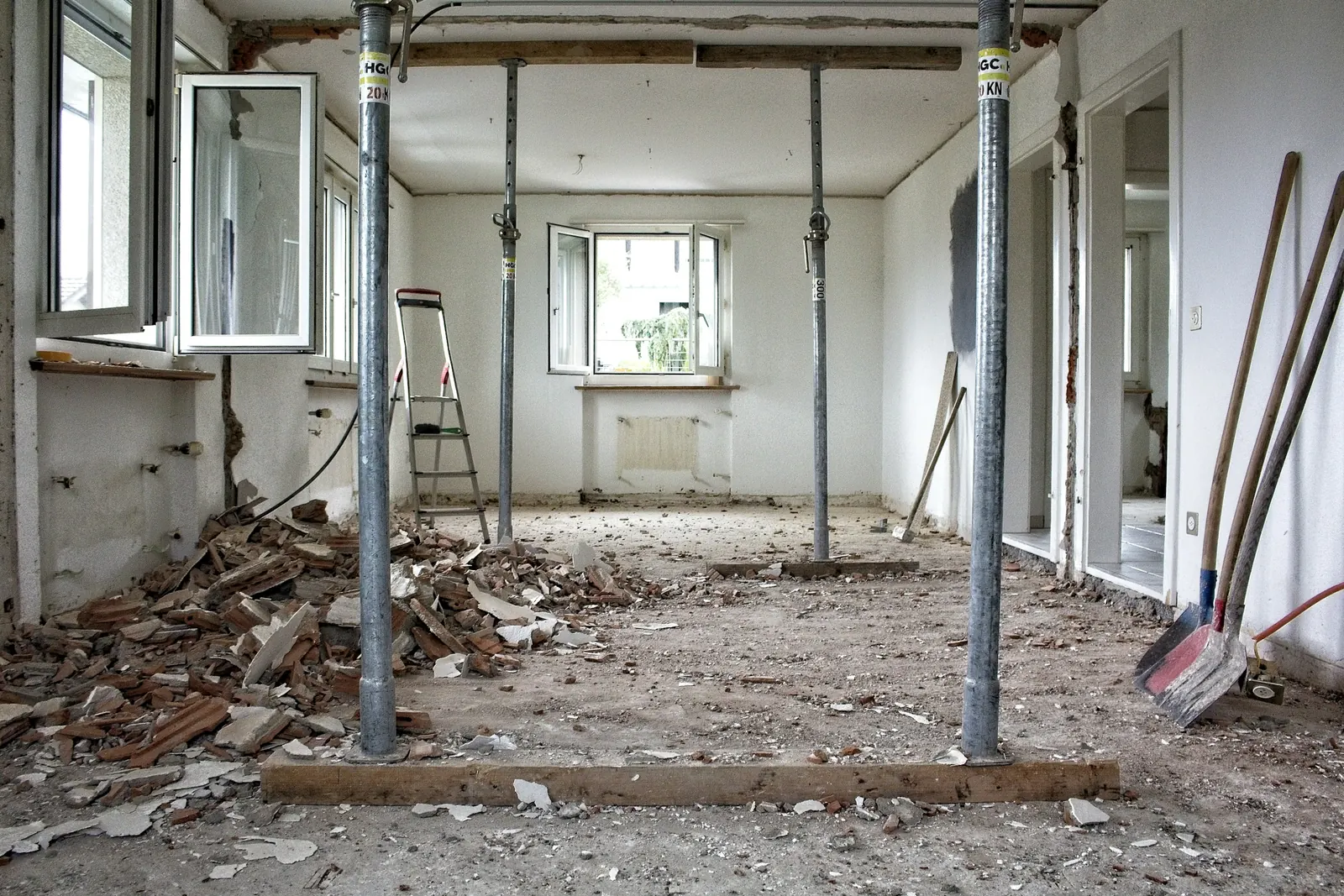 Wohnung in der Entkernung mit Bauschutt am Boden und Stützen unter der Decke