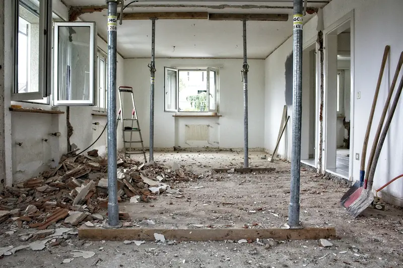 Wohnung in der Entkernung mit Bauschutt am Boden und Stützen unter der Decke